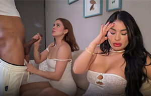 Mujer agarrando polla negra descomunal en sofá mientras su amiga de pelo negro se tapa la cara avergonzada