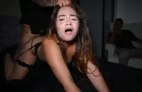 Sussy Sweet a cuatro patas en la cama con el pelo agarrado y la cara de placer con rímel corrido, mientras su novio cornudo la observa sentado en un sillón al fondo